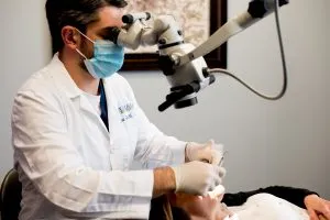 Dentist looking through a scope into a patients mouth